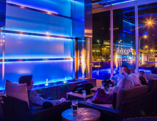 ibiza urban rooftop lounge at night. Nighttime lighting is active, giving the photo a blue and purple atmosphere.