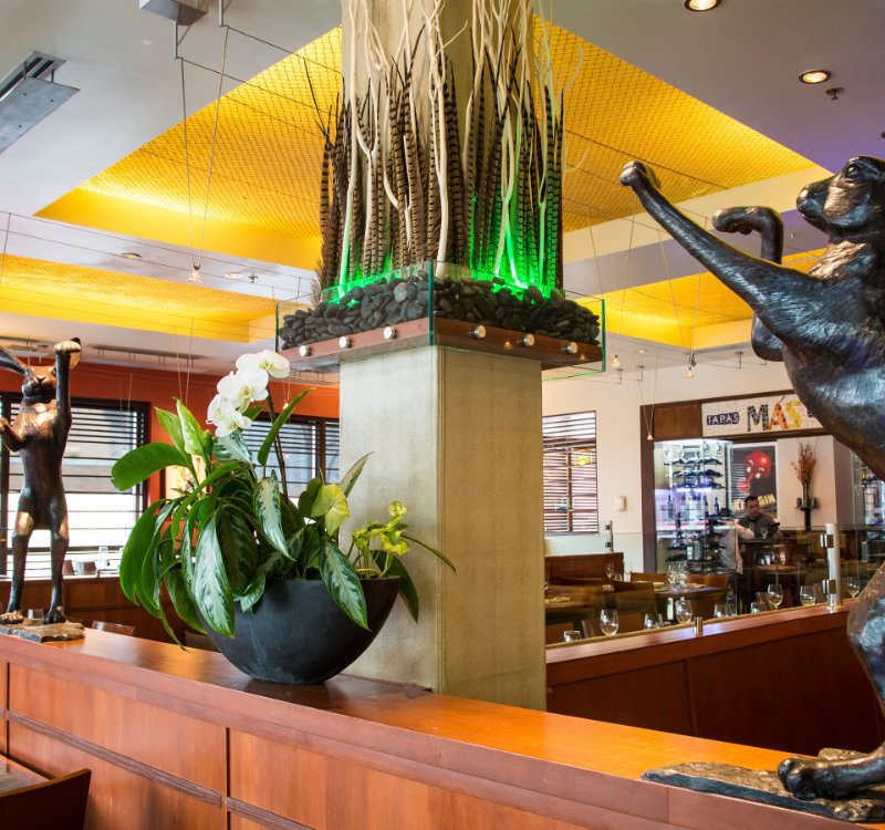 A shot of the seating at the MAS restaurant, with metal hares adorning the wooden booth separators.